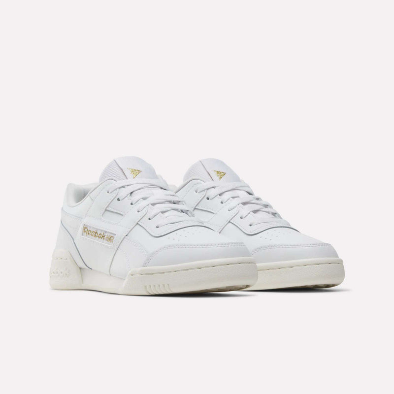 A pair of Reebok Workout Plus Shoes for big kids in white with gold logo accents on the side and tongue, stylishly displayed on a white background—perfect for juniors who want classic sporty style.