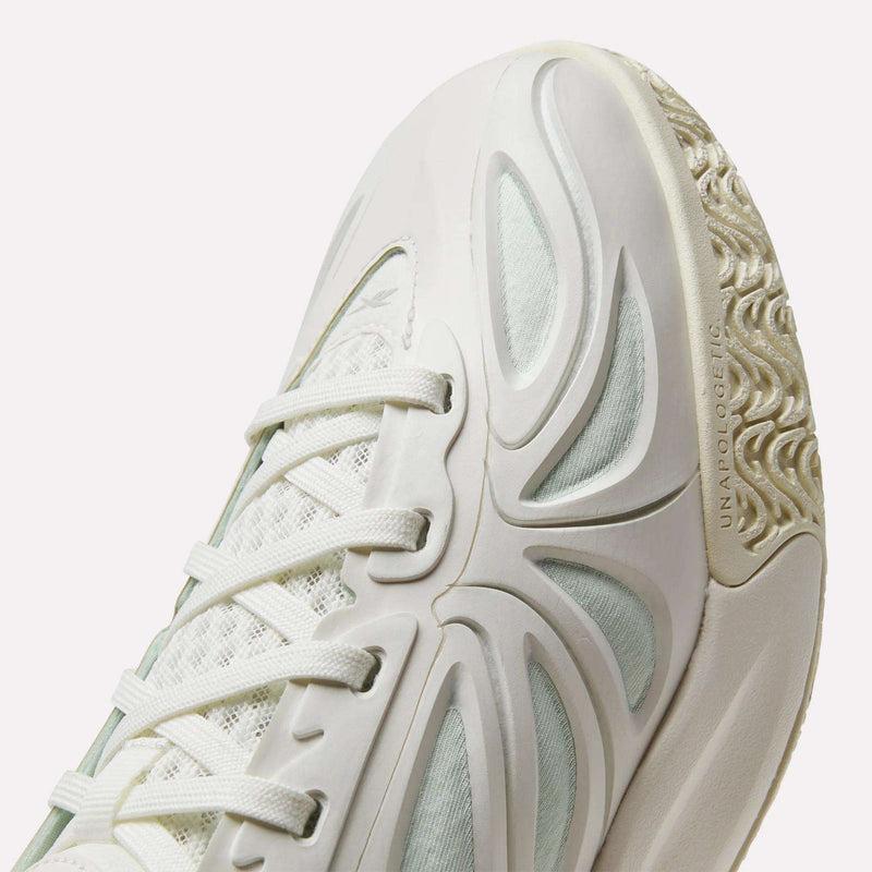 Close-up of the Angel Reese 1 Basketball Shoes by Reebok in white, showcasing textured detailing, white laces, mesh fabric, and a patterned rubber sole. The design highlights dynamic curved lines and distinctive cutouts, giving these basketball-ready sneakers a sleek, futuristic appearance. Featuring the innovative Reebok Energy Return System for standout style and exceptional comfort on the court.