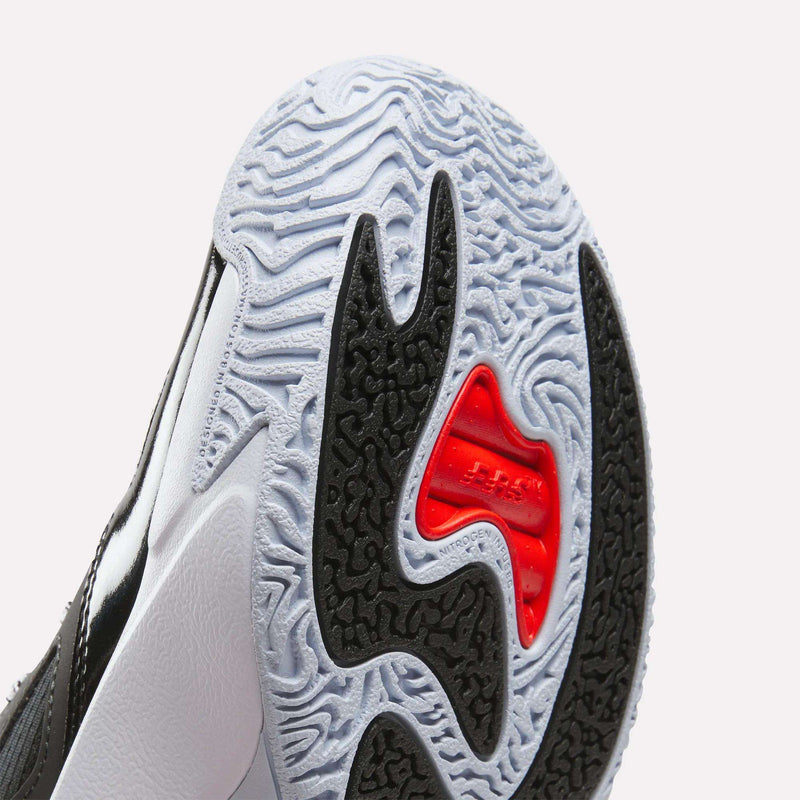 Close-up view of the sole of the Reebok Engine A 26 Basketball Shoes, highlighting intricate white and black tread patterns with a distinctive red section in the center—designed to complement the engineered mesh upper commonly found in advanced Reebok basketball footwear built for speed.