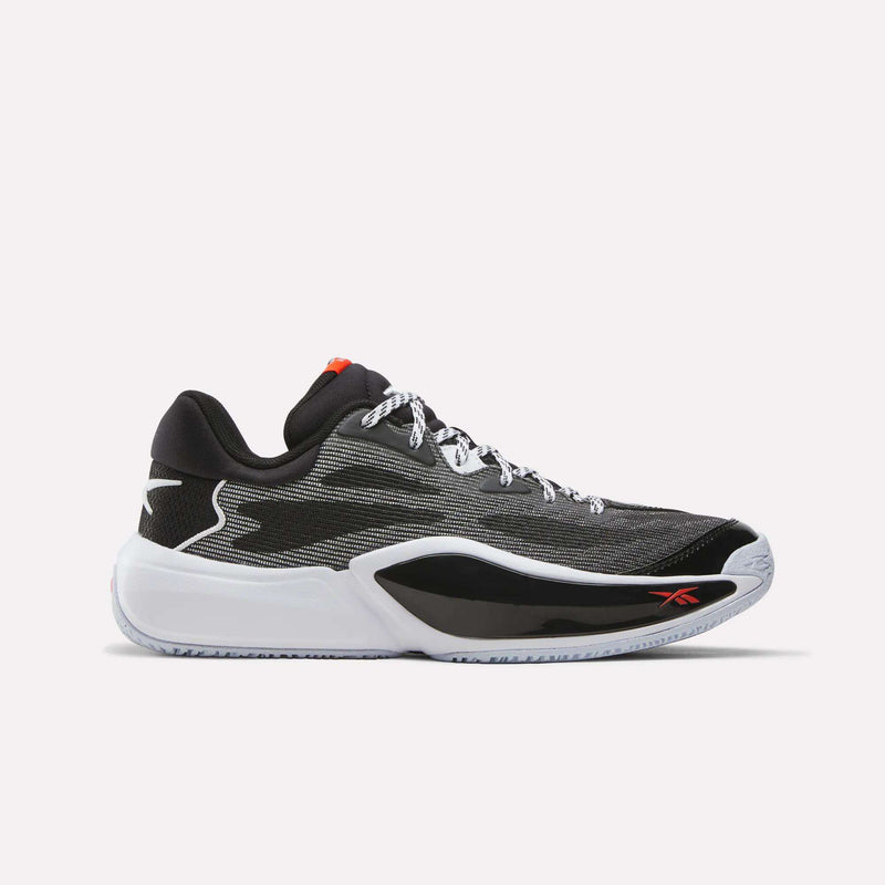 Introducing the Reebok Engine A 26 Basketball Shoes in black, white, and red—a low-top sneaker featuring an engineered mesh upper, black and white sole, white laces, and a subtle red Reebok logo on the side. Designed for speed on the court, these athletic shoes are perfect for anyone seeking performance-driven Reebok basketball footwear.