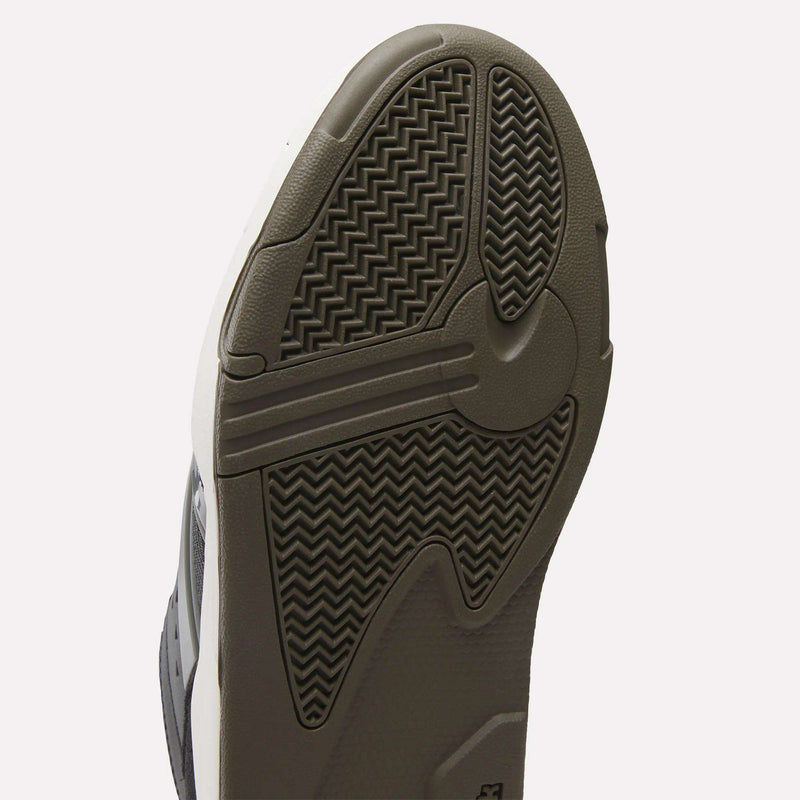 Close-up of the sole of the Reebok Omni Edge Shoes, a hoops-inspired sneaker showcasing brown and black rubber with zigzag and circular grooves for enhanced traction and durability. The upper blends premium leather and suede for elevated style and support, while a lightweight EVA midsole delivers responsive cushioning.