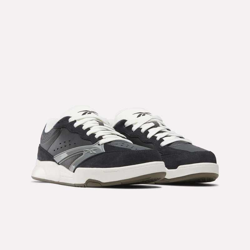 A pair of Reebok Omni Edge Shoes in black and white, featuring white laces, gray accents, and a chunky sole, crafted from premium leather and suede, displayed against a plain white background.