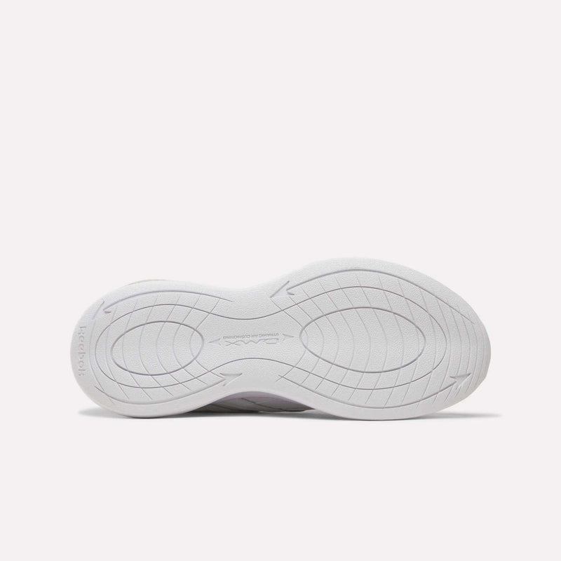 The image displays the white, textured outsole of the Reebok Men’s DMX Comfort+ Walk Ultra Shoes, viewed from beneath. The tread showcases curved and concentric lines with subtle grooves and circular accents for traction, specifically crafted to work with DMX Comfort+ cushioning for added comfort and support.