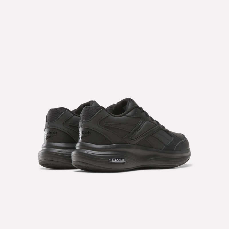 A pair of Reebok Men’s DMX Comfort+ Walk Ultra Shoes in black, showcasing thick soles and DMX Comfort+ cushioning for superior support, displayed from the back and side on a plain white background.