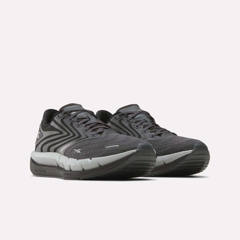 The Reebok Men's FloatZig Tread Running Shoes feature dark gray patterned mesh uppers, black laces, and a cushioned midsole—ideal for treadmill workouts—shown on a plain white background.