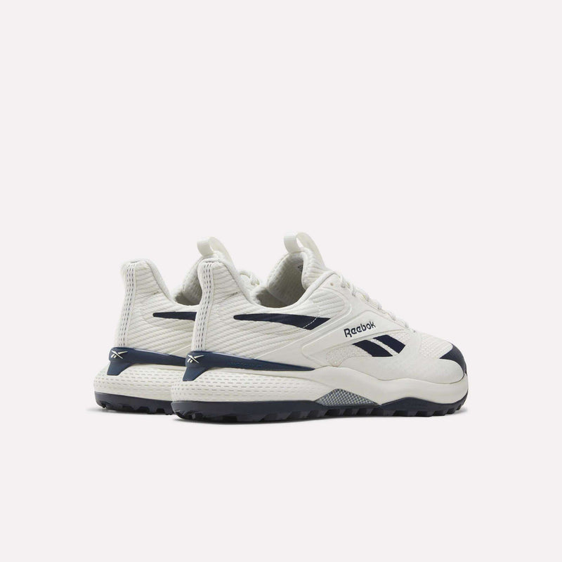 A pair of Reebok Nano Golf Shoes in white with navy blue accents, featuring innovative Floatride foam for superior comfort, is shown from the back and side against a plain white background. These lightweight sneakers are engineered to deliver top performance both on and off the golf course.