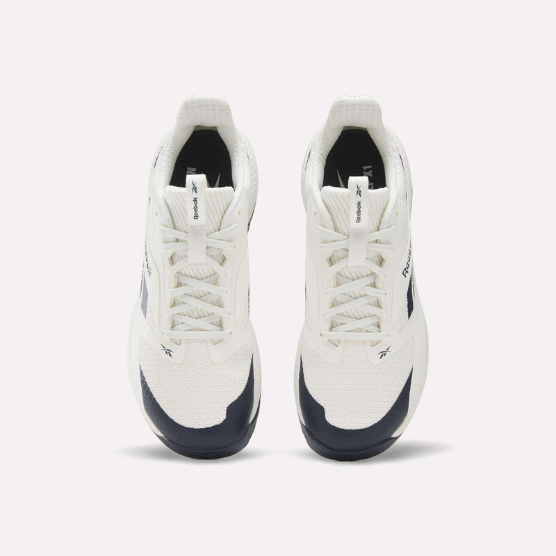 A pair of Reebok Nano Golf Shoes in white and navy, viewed from above, showcasing the laces, tongue logo, and side branding against a plain light background—these sneakers draw inspiration from lightweight golf shoes and are equipped with Floatride foam for enhanced comfort.