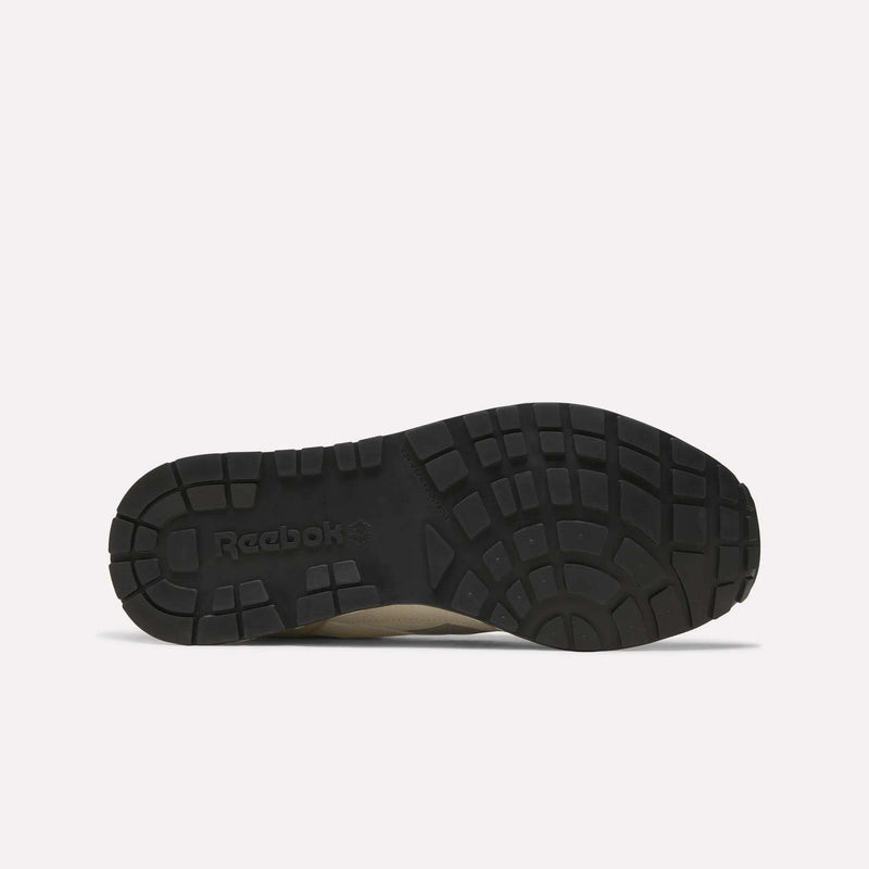 The image displays the black rubber outsole of the Men’s GL1600 Shoes by Reebok, shown from the bottom to highlight the tread pattern and embossed Reebok branding.