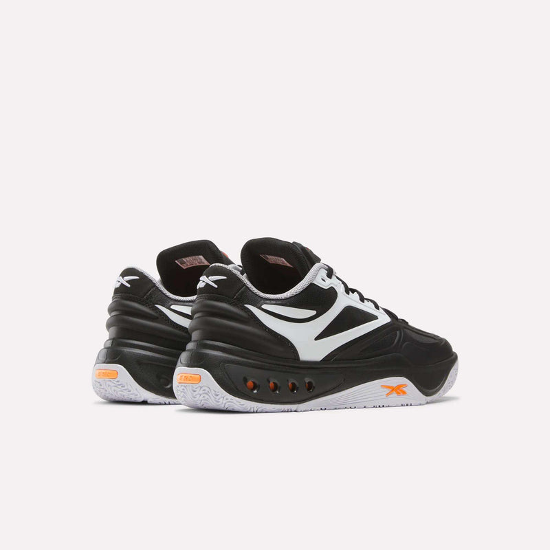 A pair of Reebok Engine A Pump Shoes in black and white with striking orange accents, showcasing advanced Pump technology inspired by performance basketball footwear, displayed from the back and side on a plain light background.