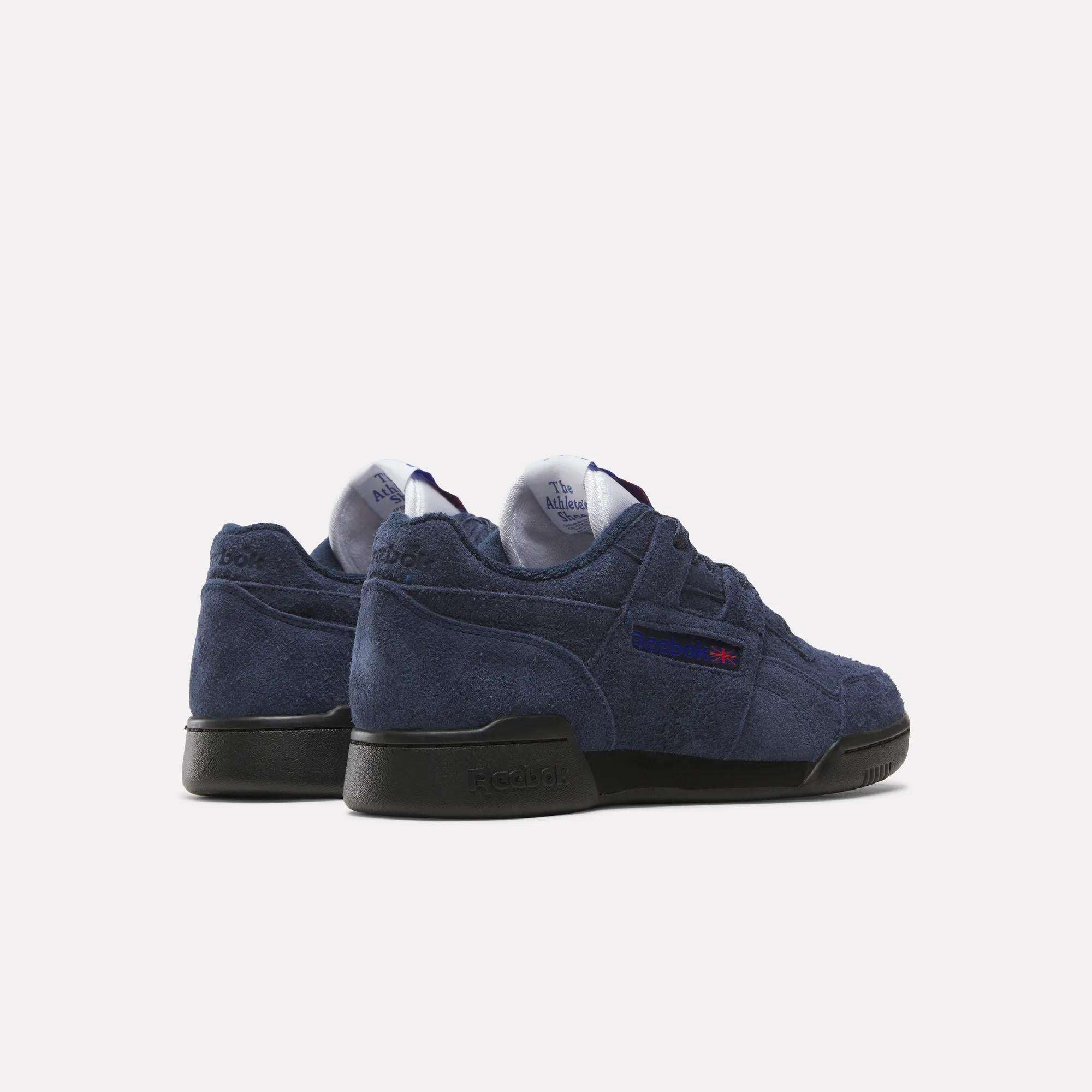 A pair of Reebok Workout Plus Shoes in navy blue suede with black soles, shown from back and side views, showcases classic '80s fitness style on a simple light background.