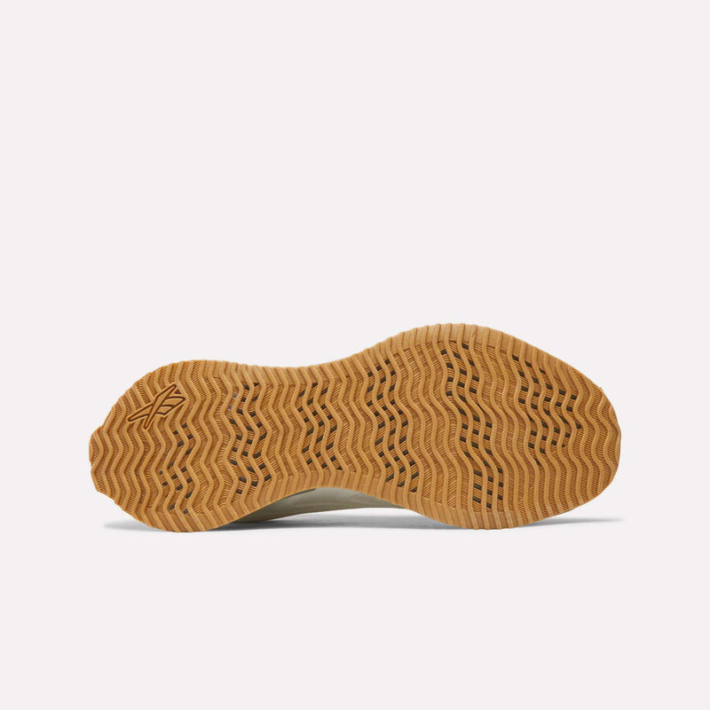 The tan, wavy-tread rubber outsole of a Women’s Zig Futaura 1.0 shoe with a FuelFoam midsole.