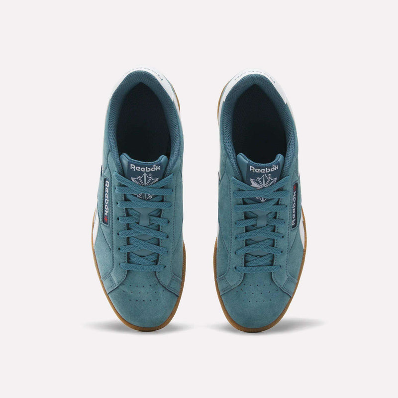 A pair of Men’s Club C Grounds UK 1.0 Shoes by Reebok viewed from above, these teal sneakers highlight premium suede uppers, gum soles, white heel tabs, and feature the Reebok logo on both the tongue and side—capturing classic Reebok heritage.
