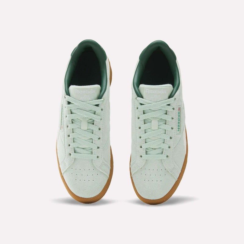 A pair of Women’s Club C Grounds UK 1.0 Shoes by Reebok in mint green, featuring gum soles, green inner lining, and a white tongue are displayed from above on a plain white background. Crafted in soft suede, these vintage-inspired sneakers offer a classic look.