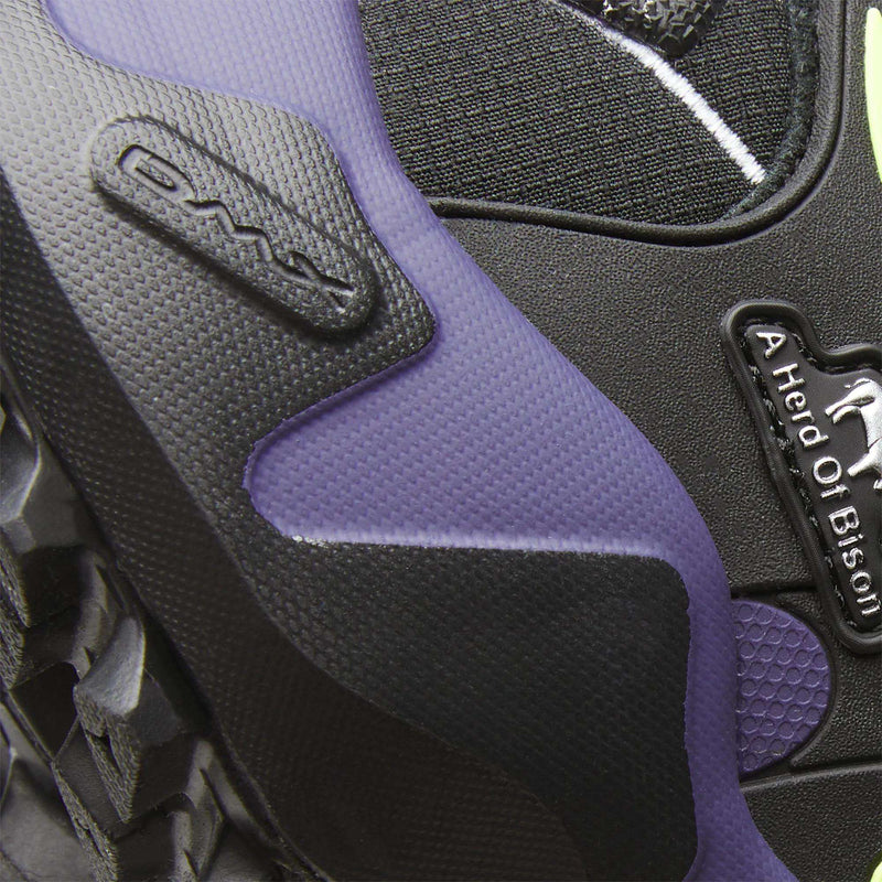 Close-up of a black Reebok x A Herd of Bison Men’s Trailzillo DMX shoe with purple accents, featuring DMX molded into the sole and a label that reads A Herd Of Bison.