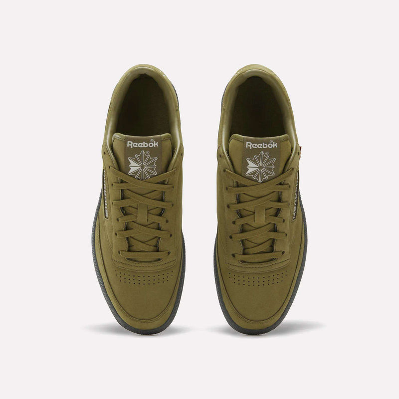 Top view of a pair of Reebok Men’s Club C 85 Shoes in olive green, featuring matching laces, white Reebok logos on the tongues, and black outsoles, displayed against a plain white background.