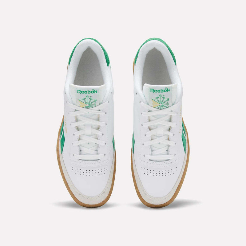 Top view of a pair of Reebok Men's Club C Revenge Vintage Shoes in white, featuring green accents, heritage branding on the tongue, and gum soles, placed side by side on a plain light background.