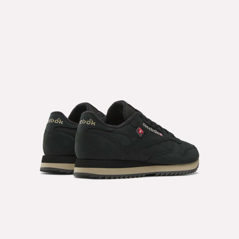 A pair of Reebok Men’s Classic Leather Ripple Shoes in black with beige soles and an EVA midsole are displayed at an angle, facing away from the camera against a plain white background.