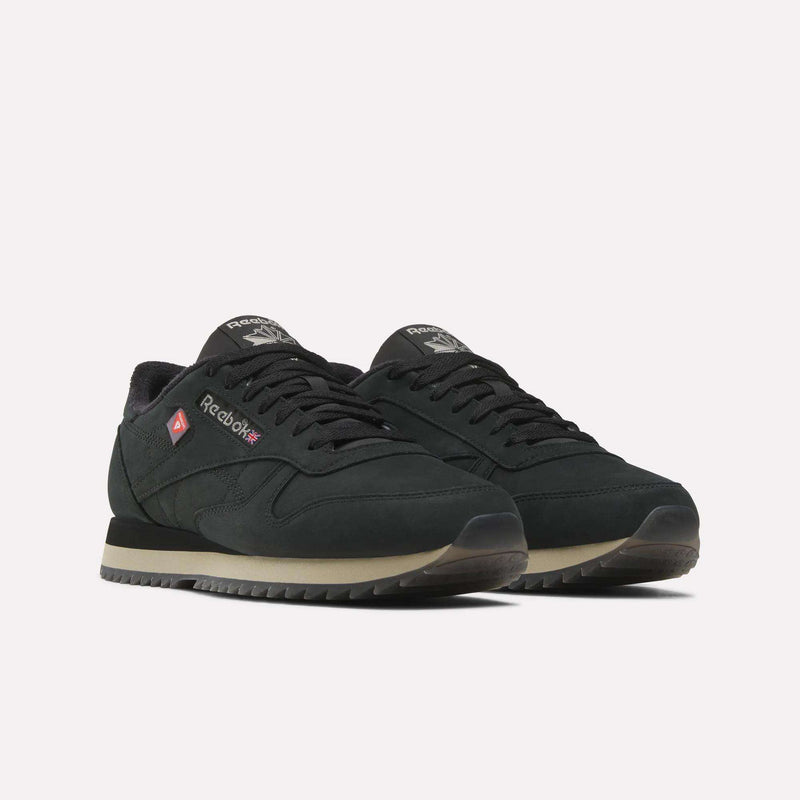 A pair of Men’s Classic Leather Ripple Shoes by Reebok in black with beige ripple soles, featuring a suede texture, supportive EVA midsole, and Reebok branding on the side and tongue, are positioned slightly facing left on a plain white background.