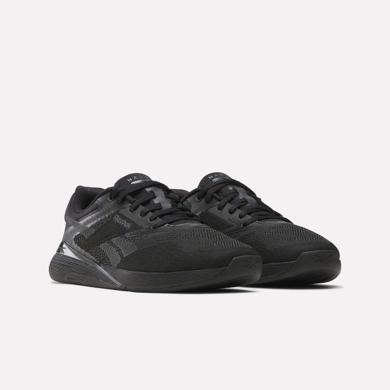 A pair of Women’s Reebok Nano X5 Training Shoes in black, engineered for comfort with breathable mesh uppers and textured soles, shown against a plain white background. Ideal for training sessions.