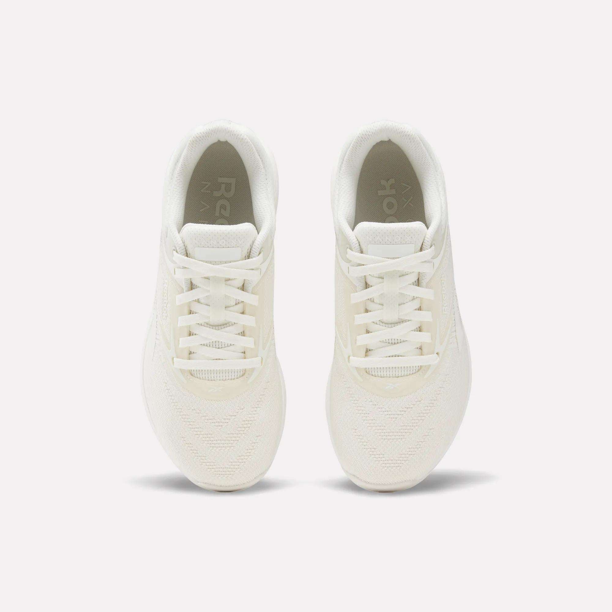 The Reebok Nano X5 Women's Training Shoes, shown from above on a plain white background, highlight their white color, laces, mesh texture, and soles.