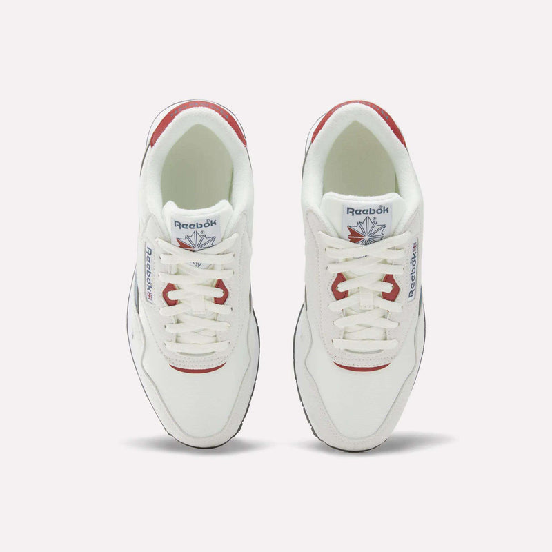 A pair of Reebok Men’s Classic Nylon Shoes in white with red accents, made from mixed materials and shown from above, featuring the signature Reebok logo on both the tongue and side. These sneakers are designed with a supportive EVA midsole for enhanced comfort.
