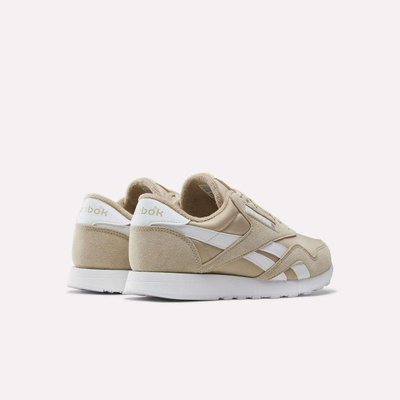 A pair of Reebok Men’s Classic Nylon Shoes in beige, featuring white accents and soles, styled as retro sneakers and displayed from the back and side angles against a plain white background.