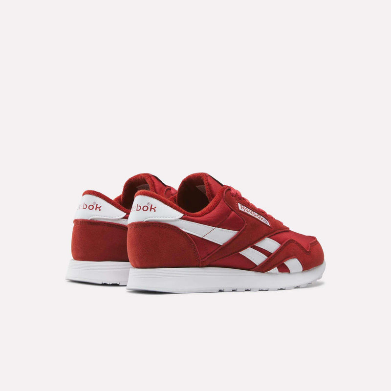 A pair of Men’s Classic Nylon Shoes by Reebok in red with white accents and logo, displayed from the back and side on a plain white background. These retro sneakers highlight timeless style, making them a must-have for any men’s shoe collection.