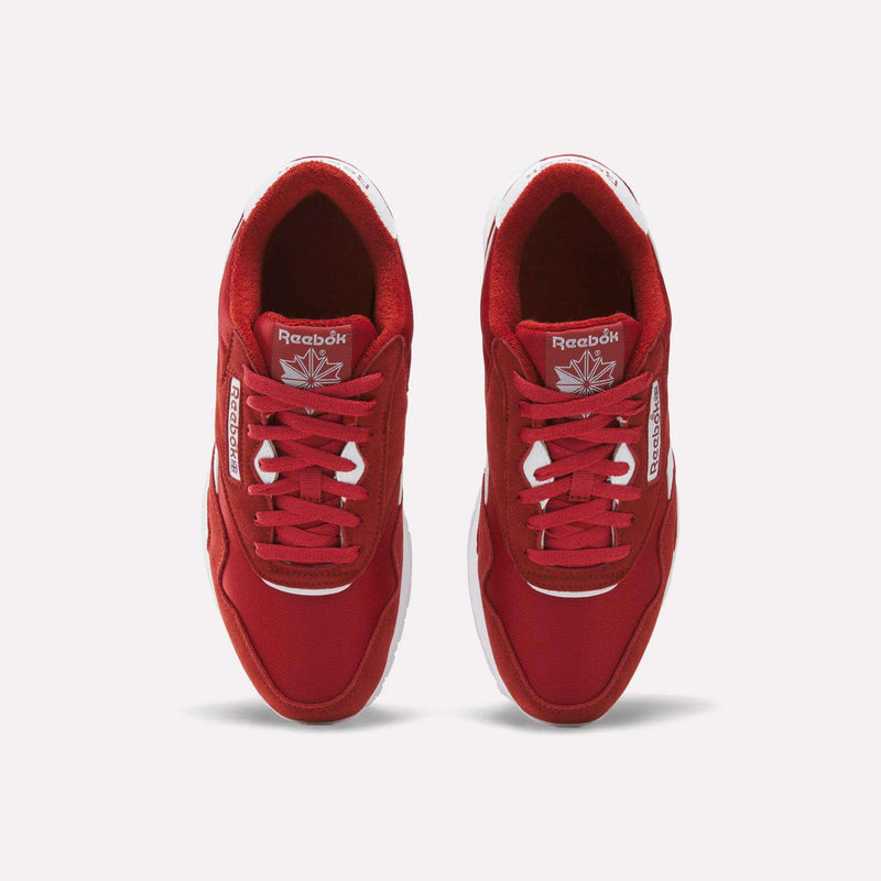 Top view of a pair of Reebok Men’s Classic Nylon Shoes in red, featuring white soles and white Reebok branding on the sides and tongue, placed side by side on a white background for an effortlessly timeless retro vibe.