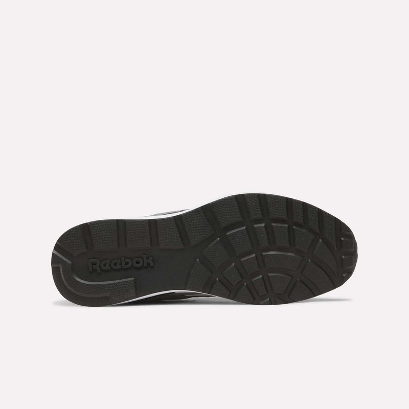 The black sole of the Men’s Run LXS Shoes by Reebok features geometric tread patterns and is shown from below against a plain white background. Crafted from full-grain leather, this retro running shoe displays the Reebok logo on the left side of the sole.
