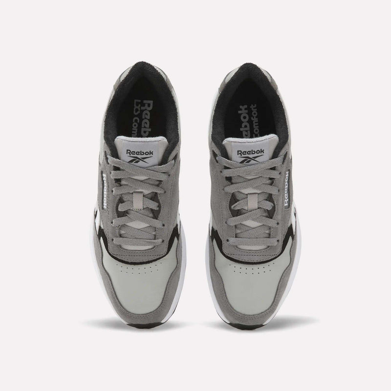 A pair of Reebok Men’s Run LXS Shoes in gray and white are shown from above, crafted from full-grain leather with visible laces, a perforated toe area, and Reebok branding on both the tongues and sides. These classic men’s sneakers feature a retro running shoe silhouette that blends timeless style with lasting comfort.