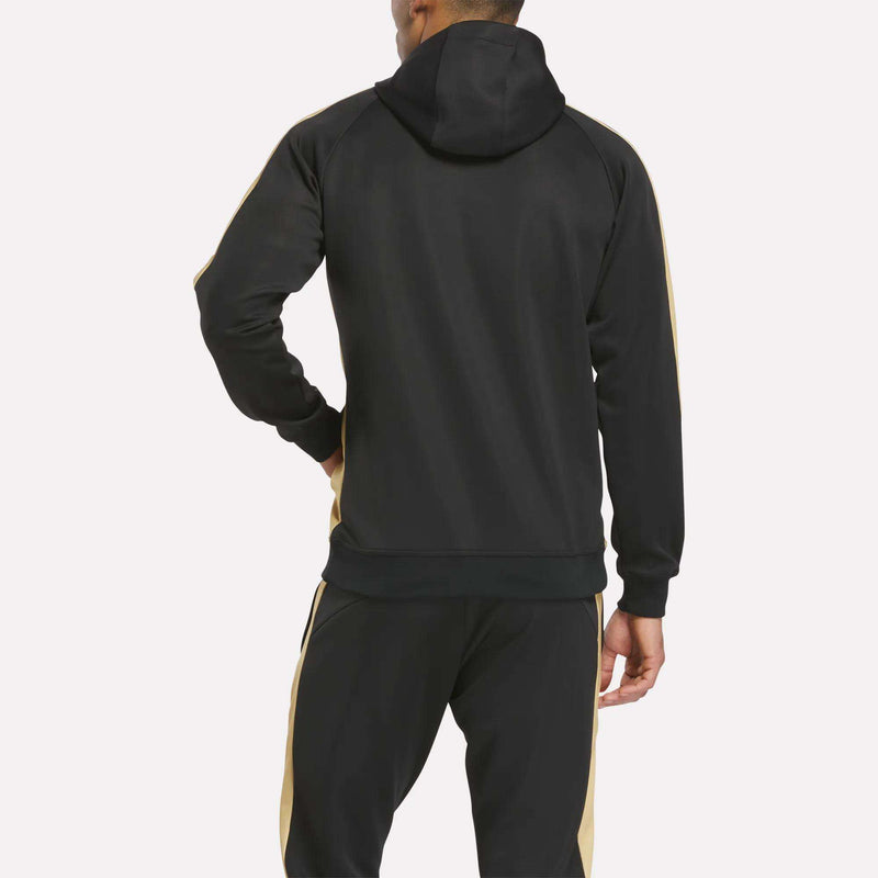 A person is seen from the back, wearing a black Reebok Men's MK Dons Travel Hoodie with gold stripes, set against a plain white background.