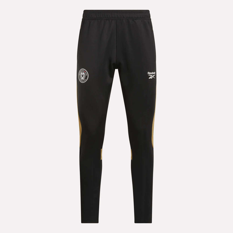 Reebok Men's MK Dons Travel Pants feature an elastic waistband, white logo and crest on the thighs, and yellow accents below the knees—ideal men's travel pants for dedicated football fans.