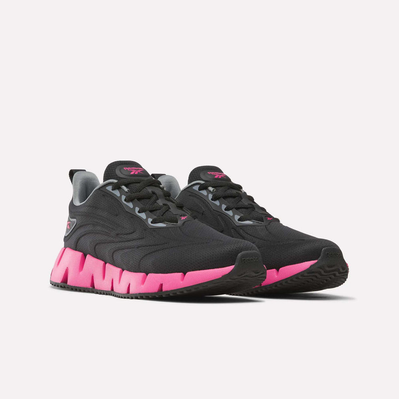 Women’s Zig Futaura 1.0 Shoes featuring black mesh uppers, grey collars, pink zigzag patterned FuelFoam midsoles, and black outsoles.