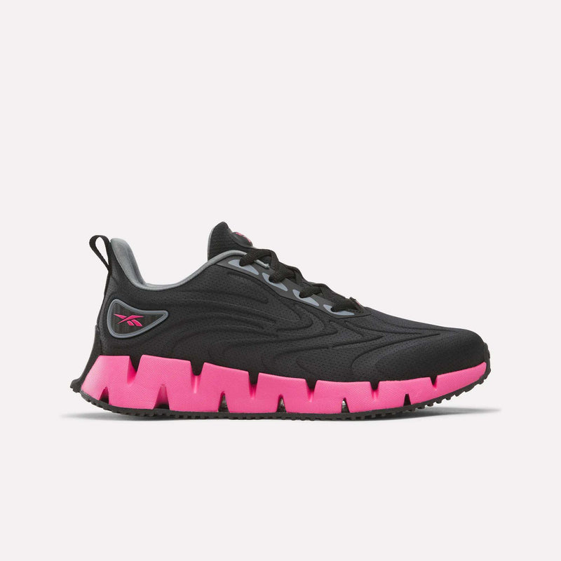 Women’s Zig Futaura 1.0 Shoes in black with a mesh upper and a bright pink zigzag-shaped sole.