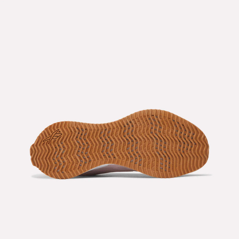Bottom view of a Reebok Women’s Zig Futaura 1.0 shoe with a wavy, gum-colored rubber outsole and FuelFoam midsole.