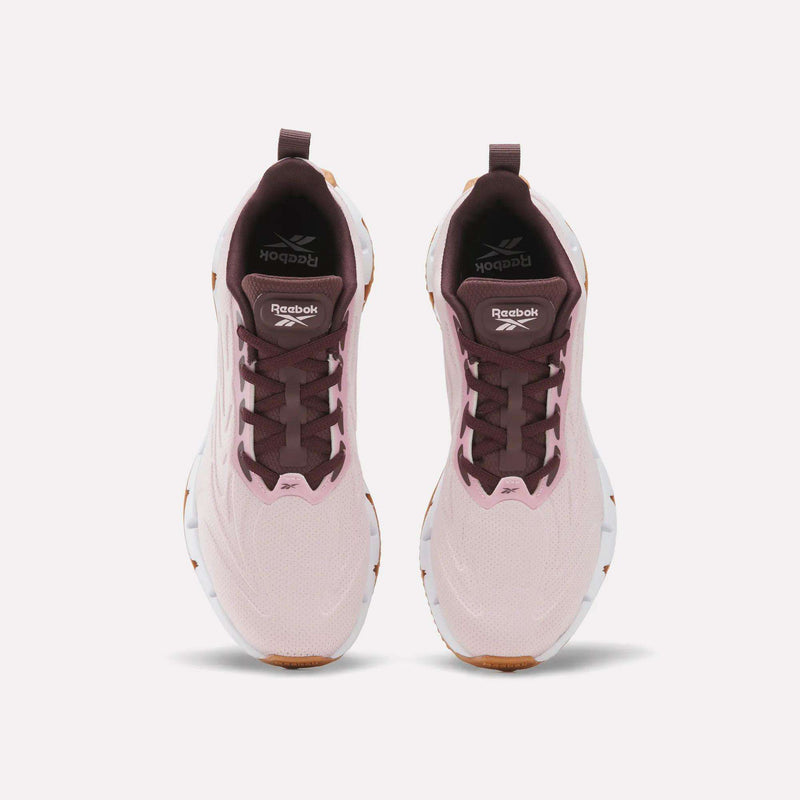 Women’s Zig Futaura 1.0 Shoes in light pink with dark maroon tongues, laces, and collars, set on white zigzag-patterned FuelFoam midsoles with gum rubber outsoles.