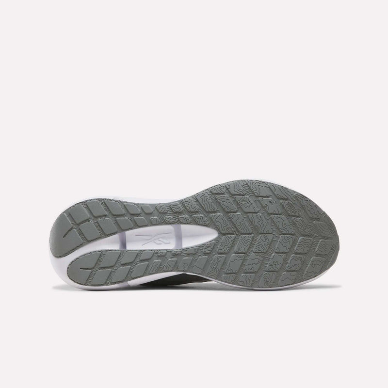 The image displays the gray treaded outsole of the Reebok Men’s Zignition Running Shoes, viewed from below against a plain white background. The sole features a wider forefoot area with a textured grip pattern and showcases the Reebok logo at the midfoot.