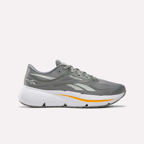 The Reebok Men’s Zignition Running Shoes in Grey/White feature a mesh upper, a wide forefoot for extra comfort, springy cushioning, white and yellow accents, and a white sole, shown against a plain white background.