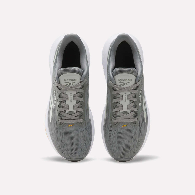 A pair of Reebok Men’s Zignition Running Shoes in gray, shown from above, featuring white midsoles and breathable mesh uppers. The Reebok logo appears on the tongue and side of each shoe. These shoes offer springy cushioning and a wider forefoot for enhanced comfort with every stride.