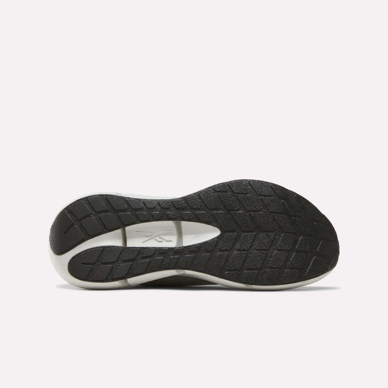 The sole of the Reebok Men’s Zignition Running Shoes is black and white with a textured tread pattern, featuring a wider forefoot for enhanced stability, shown from the bottom against a plain white background.