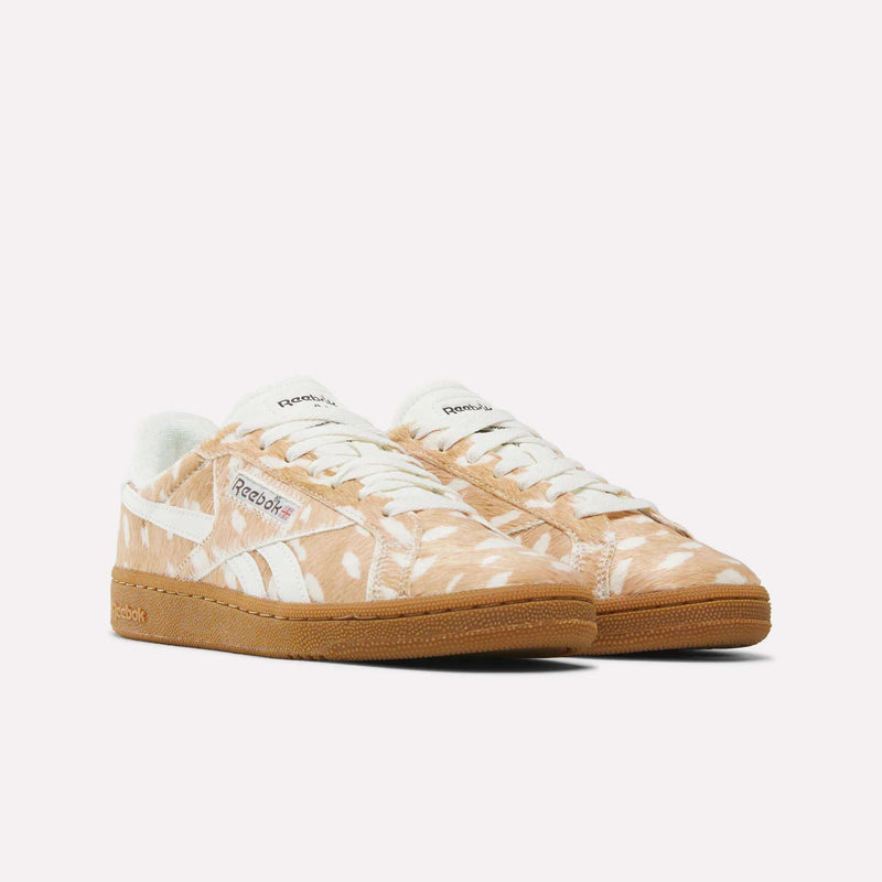 Women’s Club C Grounds UK 1.0 Shoes by Reebok in tan, featuring a white abstract animal print, white laces, a white Reebok logo, and gum soles. The sneakers are displayed side by side, angled slightly to the right on a plain white background.