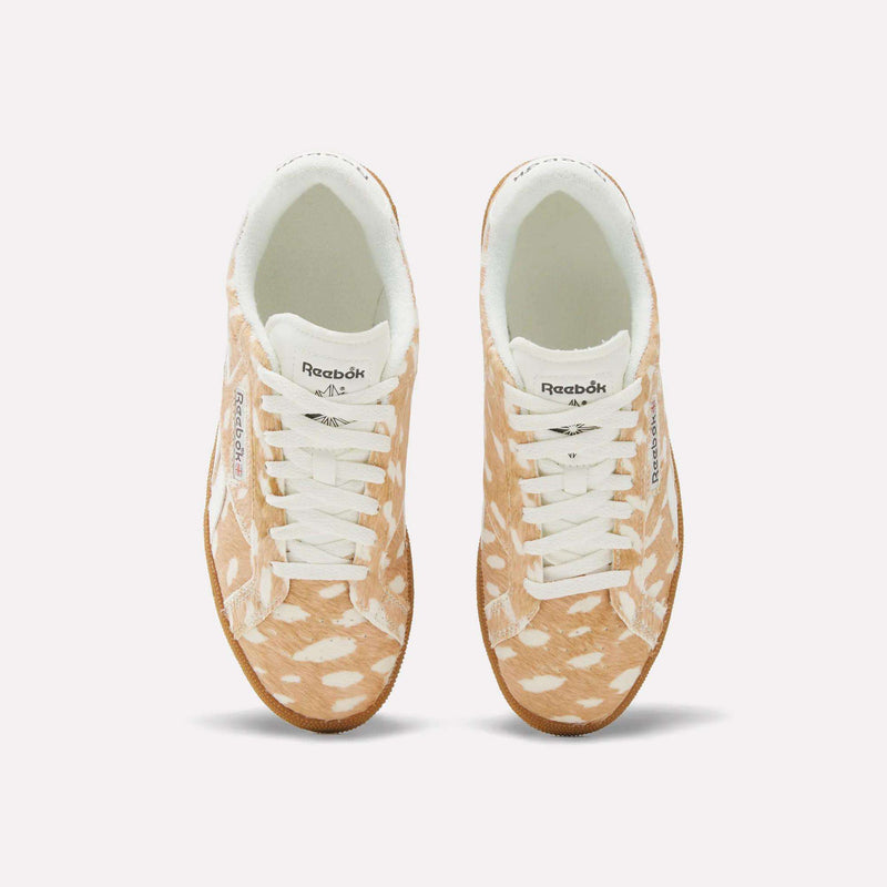 A pair of Women’s Club C Grounds UK 1.0 Shoes by Reebok with a brown and white spotted animal print pattern resembling a fawn’s fur, viewed from above, featuring white laces and a white interior lining.