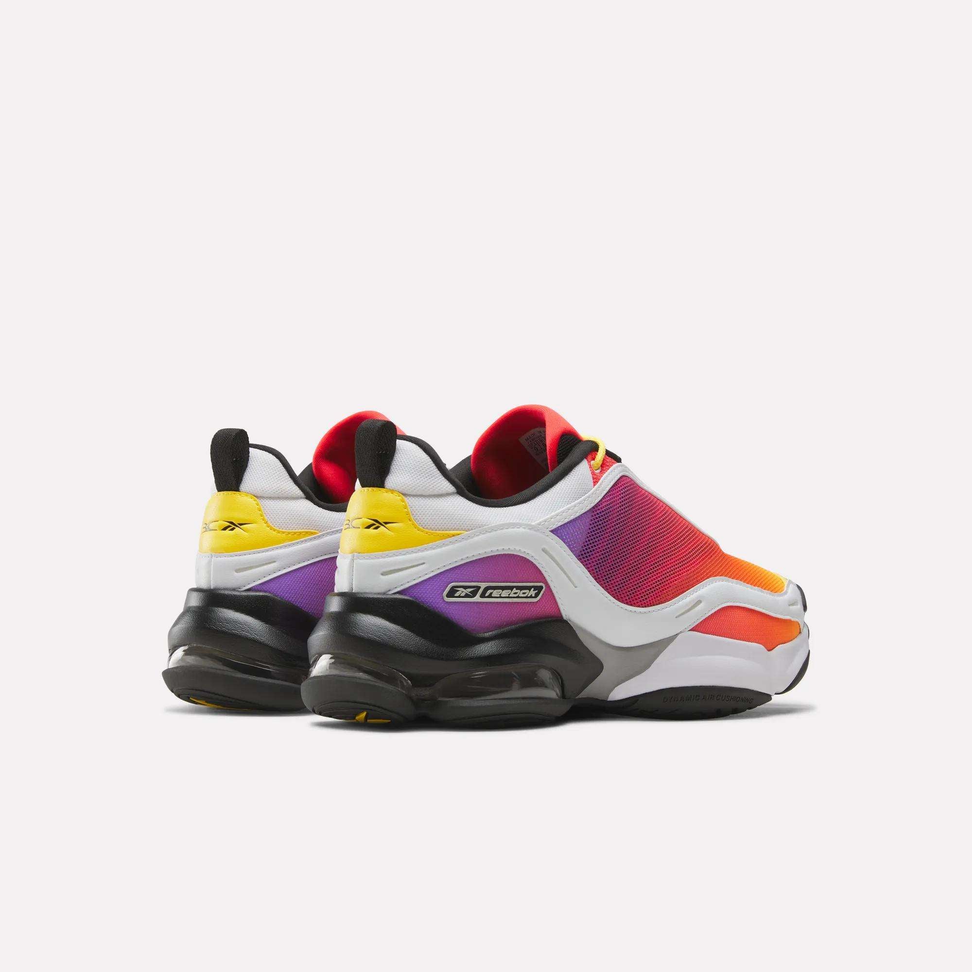 The Reebok x Brain Child DMX Series 3000 Shoes feature white, orange, red, purple, and yellow panels with black heels, soles, and pull tabs, seen from the back at an angle on a white background.