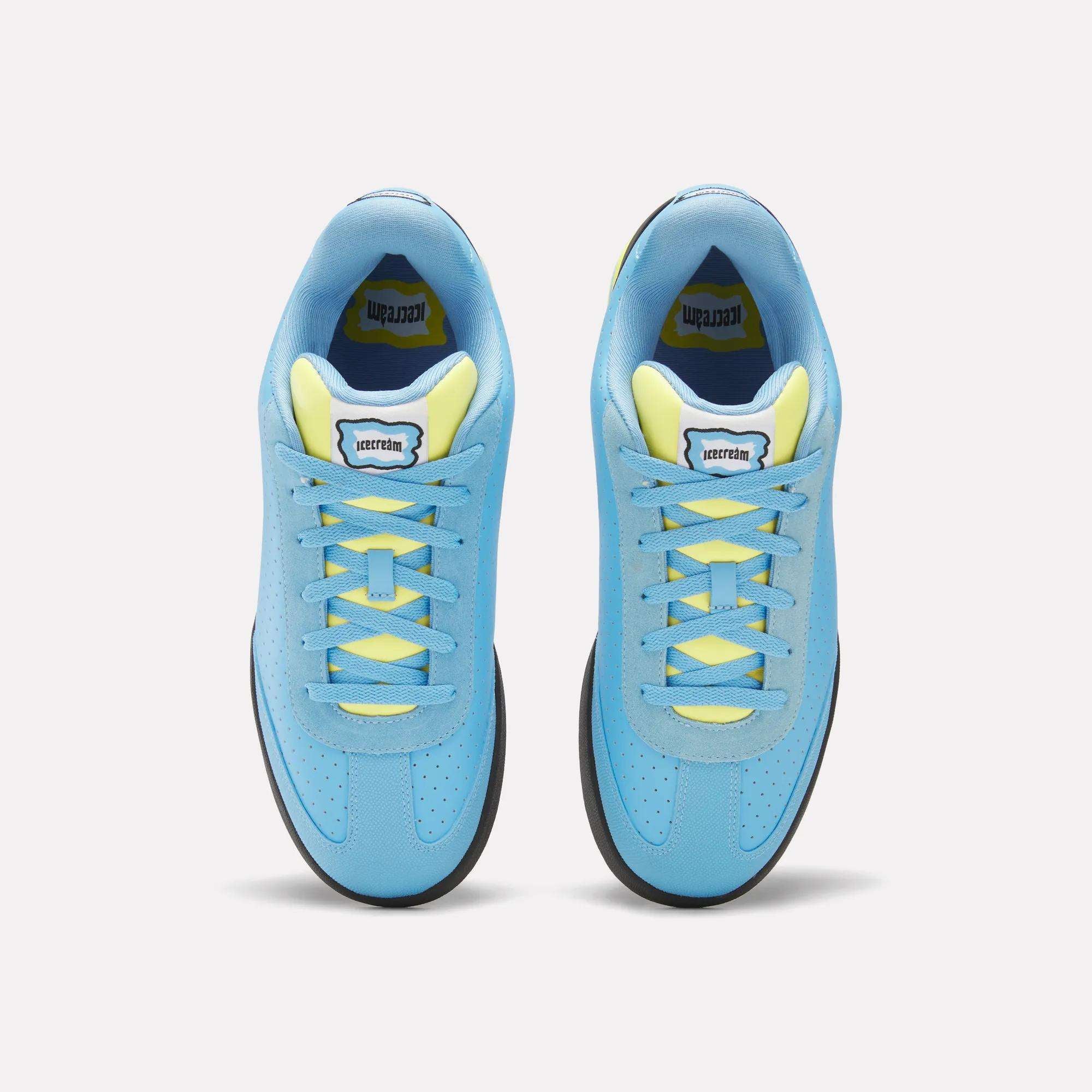 A pair of Reebok x Icecream Board Flip Shoes in blue with yellow laces and inner lining, seen from above on a light background. Early-2000s style sneakers feature a rectangular tongue label with black text.