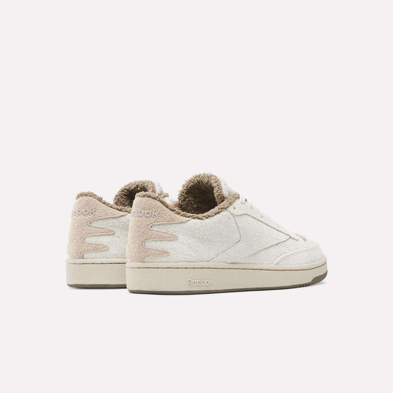 Off-white low-top Reebok x Avatar Club C 85 Shoes with a fuzzy brown lining and wavy detailing on the heel.