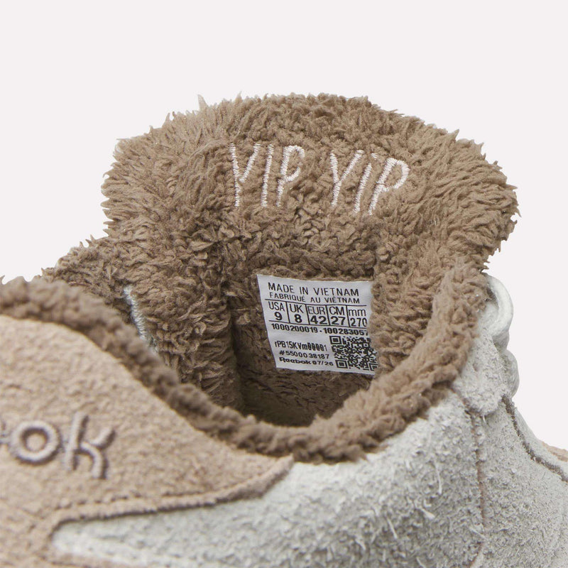 Interior of a Reebok x Avatar Club C 85 shoe lined with brown faux fur, featuring YIP YIP embroidered on the tongue and a size label showing manufacturing details.