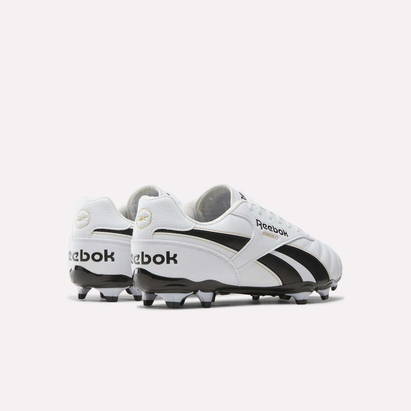 A pair of RBK800 League Firm Ground Soccer Cleats by Reebok are displayed from the back and side, featuring the Reebok logo and classic design in white and black on a plain white background.
