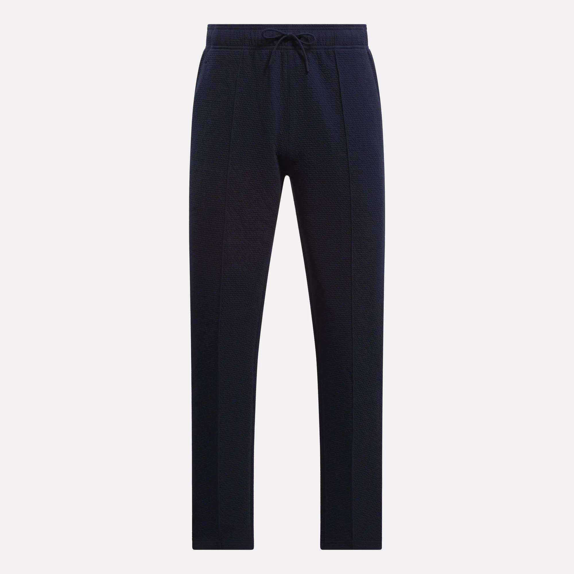 Reebok Men's Club Sport Textured Pants in navy blue, featuring a thermal knit, straight-leg fit, front seam details, and an elastic drawstring waistband—ideal for cool weather. Shown against a plain white background.