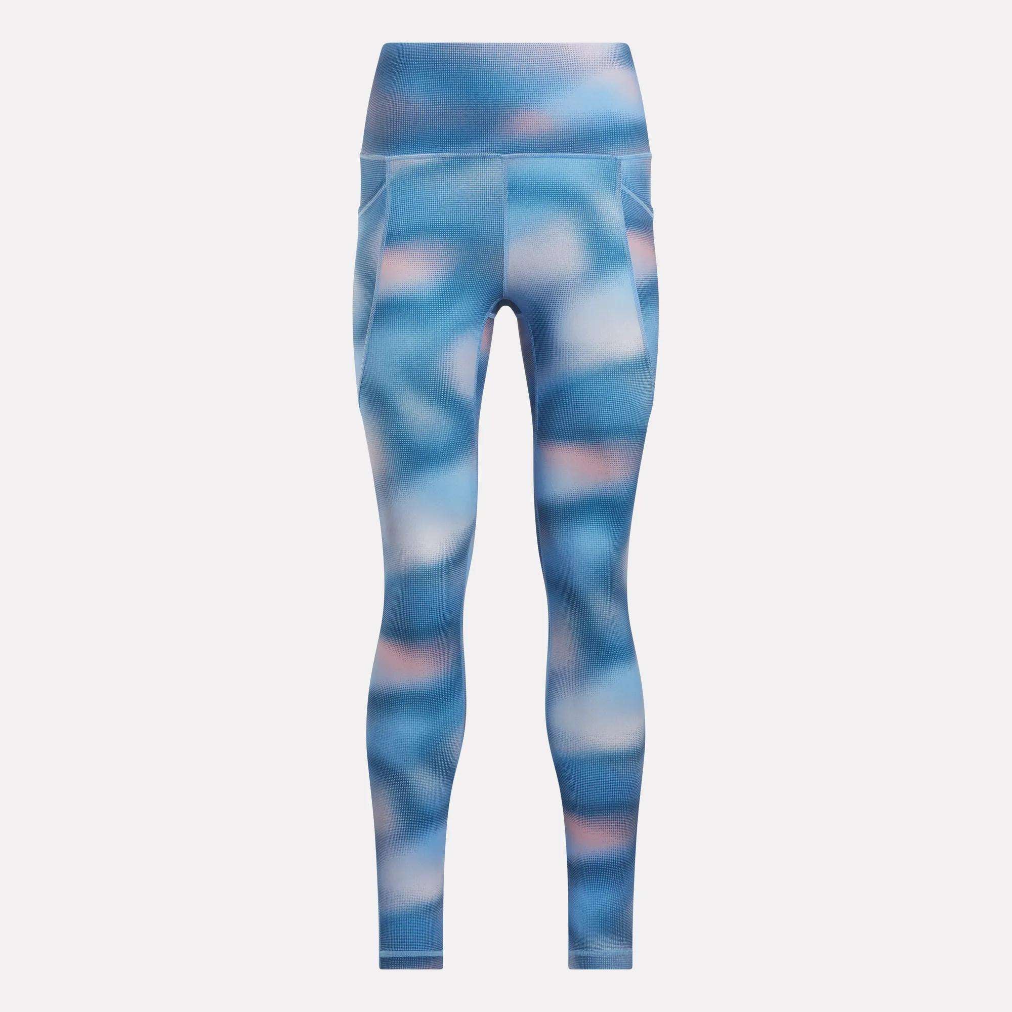 The Reebok Women’s Fluid Print High-Rise Tights feature a blue and pink abstract pattern, side pockets, moisture-wicking fabric, and a smooth, fitted silhouette—all shown against a plain white background.
