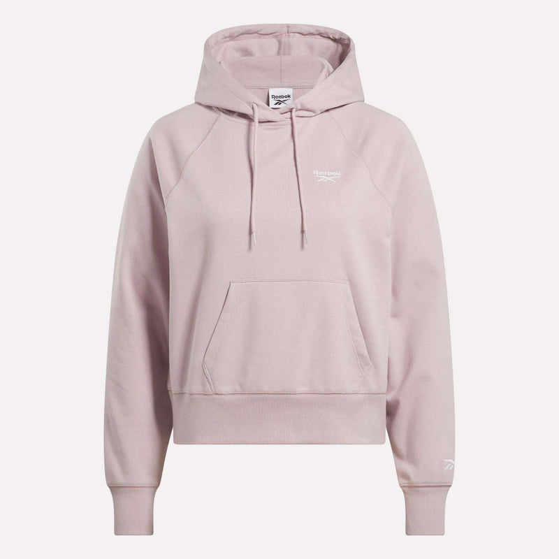 The Women's Small Vector Cropped Hoodie by Reebok comes in light pink French terry, featuring a front pocket, drawstrings, and white logos on the chest and sleeve. Shown against a plain white background.